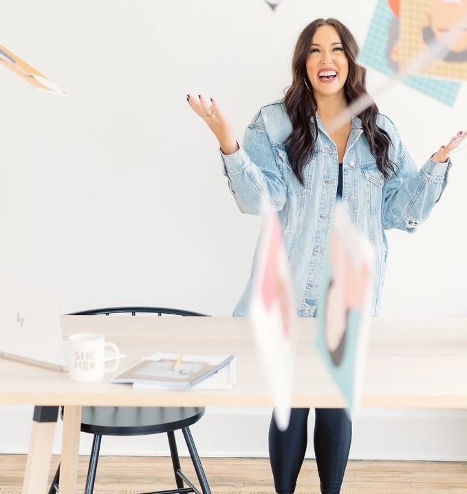 Brittany at her desk, tossing papers in the air